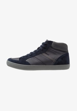 Zapatillas altas de ante azul marino oscuro con acentos de cuero texturizado, suela de goma gris y rayas tonales. Presenta cordones para un ajuste seguro.