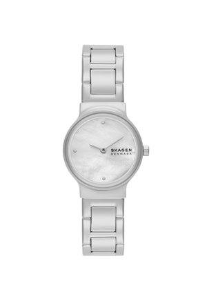 Montre analogique argentée avec un bracelet en métal, un boîtier rond et un cadran en nacre blanche présentant des marqueurs d'heure minimalistes et des aiguilles.