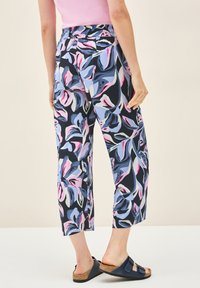 Bedrukte cropped broek in marineblauw met roze en lichtblauwe bloemenpatronen. Voorzien van een elastische tailleband en een relaxed fit.