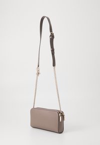 Hnědá kožená crossbody taška s hladkým povrchem, vybavená řetízkovým a textilním popruhem pro všestrannost, a zipovým uzávěrem na vrchu.