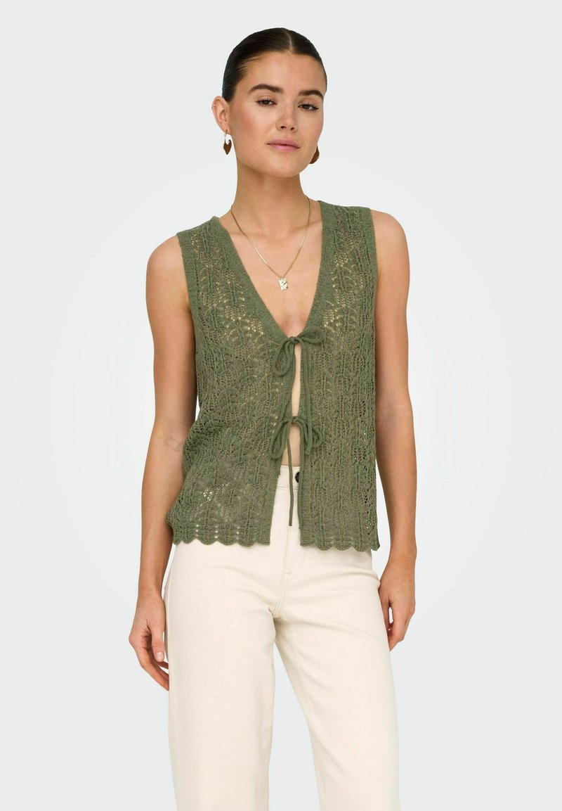 Sukienka bez rękawów w oliwkowym kolorze z dekoltem w kształcie litery V i z przodem wiązanym, posiadająca falbaniaste wykończenie i skomplikowany wzór z koronki.