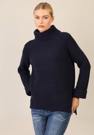 Marineblauer Ripp-Strickpullover mit lockerer Passform, langen Ärmeln und umgeschlagenen Bündchen, gefertigt aus einem dick strukturierten Gewebe.