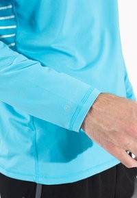 Blå langærmet atletisk skjorte med UPF 30+ beskyttelse, glat tekstur og kontrastsyning på ærmet.