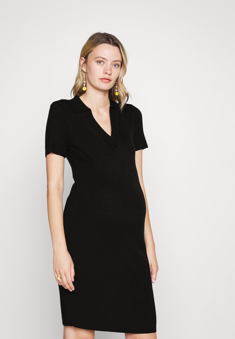 Vestido preto justo com mangas curtas, colarinho em V e uma textura suave. Apresenta um design na altura do joelho. Simples e versátil.