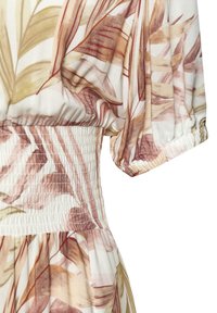 Vaate dengan pola floral dan pinggang smocked. Menampilkan kain yang lembut dan ringan dalam nuansa krim, cokelat, dan hijau, dengan lengan pendek yang menggelembung.