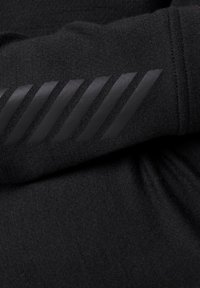 Zwarte stof met een gladde textuur, voorzien van een diagonaal gestreepte rubberachtige accent op één mouw voor extra detail.