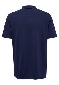 Mörkblå polo med kort ärm, platt krage och en mjuk bomullstextur. Har en enda bakre yoke utan utsmyckningar.