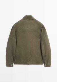 Olivengrøn langærmet jakke med en lige krave, knappede manchetter og minimal sømdetaljering, vist bagfra på en hvid baggrund.