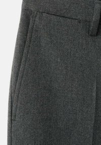 Tissu gris foncé avec une poche latérale verticale et une passant de ceinture sur un pantalon ou pantalon sur mesure.