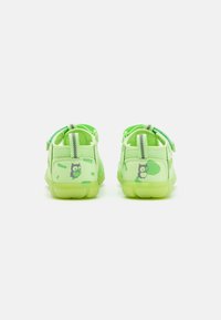 Grünes Schuhwerk mit einem Mesh-Design, verstellbarem Riemen und Eulen-Print-Akzenten auf der Rückseite, ausgestattet mit einer transparenten Sohle für zusätzliche Sichtbarkeit.