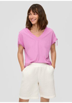 Pink V-neck short-sleeve top with drawstring details, paired with textured white shorts featuring an elastic waistband and side pockets.