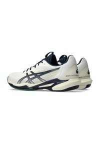 Witte sportschoenen met een gestructureerd bovenwerk, marineblauwe accenten en kenmerkende zijstrepen. Voorzien van een gevoerde zool en een ondersteunende hielkap.