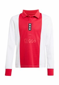 Červená a biela polo košeľa s dlhým rukávom a golierom. Obsahuje čierne akcenty, vyšitý logo a tri čierne hviezdy vpredu.