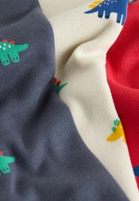 Pletená tkanina s částmi v šedé, krémové a červené barvě, se vzory barevných dinosaurů a strukturovanými úplety.