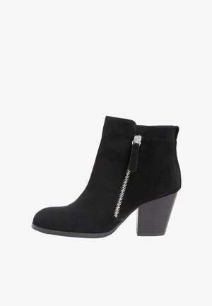 Mustat mokkanahkaiset nilkkurit, joissa kapeneva kärki, sivuvetoketjusomiste ja paksu korko. Sileä pinta ja minimalistinen muotoilu.