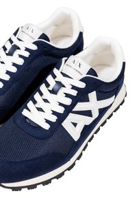 Zapatillas azul marino hechas de malla y ante, con cordones blancos, un acento de logo blanco y una suela de goma texturizada.