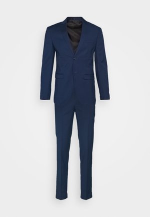 Costume marine avec une veste à un bouton, des revers en satin et un pantalon à taille plate. Fabriqué en tissu lisse avec une coupe ajustée.