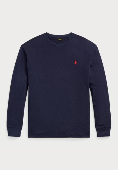 Marineblå langærmet t-shirt lavet af blød bomuld. Har en rund halsudskæring og et lille rødt logo på venstre bryst. Glat tekstur hele vejen igennem.