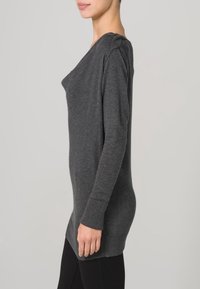 Grijze lange mouwen gebreide trui met een relaxed fit, geribde manchetten en zoom, en een subtiele gedrapeerde halslijn. Zachte textuur zonder patronen.
