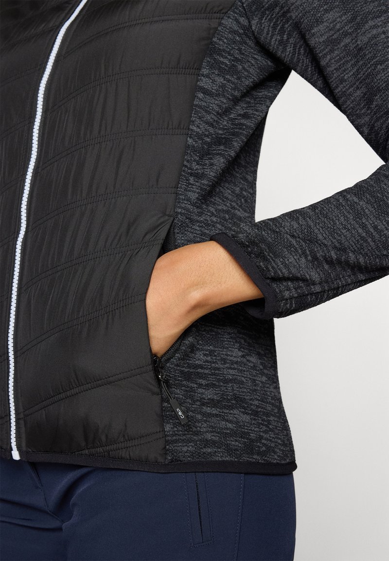 Schwarze isolierte Jacke mit einer gesteppten Textur auf der Vorderseite und einem glatten, dunkelgrauen Stoff an den Ärmeln, mit einer Reißverschlusstasche.