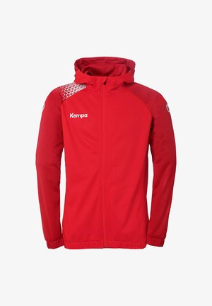 Rode lichtgewicht jas met een capuchon, voorzien van een wit geometrisch patroon op de schouder en het "Kempa"-logo op de voorkant gedrukt.
