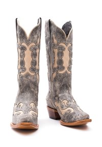 Stivali in stile occidentale con un esterno in pelle grigio argento, cuciture intricate, accenti color beige chiaro, punte appuntite e tacchi impilati.