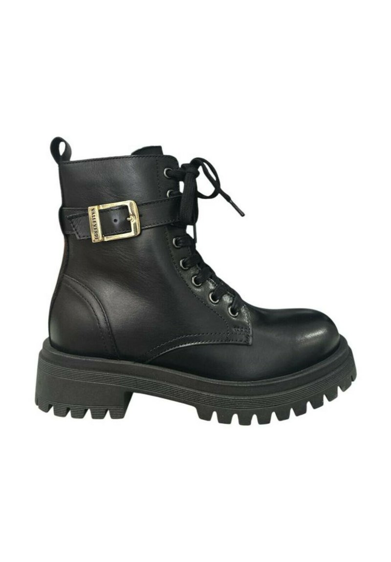 Stivaletto in pelle nera con lacci frontali, dettaglio fibbia sulla cinghia alla caviglia e suola in gomma spessa e rigata. Texture liscia, design resistente.