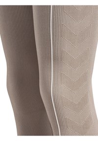 Collant a coste beige con un motivo a zigzag e una linea bianca accentuata lungo il lato, che mette in evidenza il tessuto testurizzato.