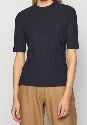 Haut en tricot à manches courtes bleu marine avec un motif texturé de rayures et de nervures, présentant un col rond et une silhouette ajustée.
