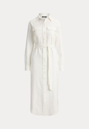 Μακρύ λευκό φόρεμα με κουμπιά, γιακά, μακριά μανίκια, δύο τσέπες στο στήθος και ζώνη από το ίδιο ύφασμα στη μέση.