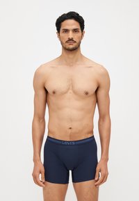 Navy blue Levi's boxer briefs with a soft texture and a contrasting waistband logo, featuring a close-fit design and mid-thigh length.