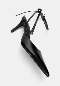 Scarpe nere con tacco alto, punta affusolata, tomaia in pelle liscia e dettaglio della cinghia alla caviglia con fibbia. Design con tacco a stiletto.