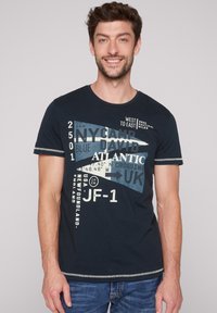 Camiseta de color navy hecha de algodón con cuello redondo, que presenta acentos gráficos en texto blanco y azul, y un borde texturizado en las mangas.