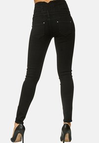 Schwarze Skinny-Jeans mit hoher Taille, strukturiertem Bund und Gesäßtaschen. Mit silberfarbenen Hardware-Details und figurnahen Schnitt.