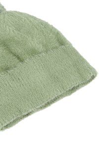Cappello beanie verde in maglia pelosa con superficie texturizzata e bordo a coste, realizzato in un tessuto morbido, leggero e caldo.