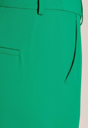 Green pants made of a smooth, stretchy fabric featuring a discreet pocket and a straight-leg design, showcasing a solid color with no patterns.