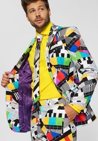 Multicolored suit with geometric patterns in black, white, and vibrant colors. Yellow shirt and purple lining in jacket. Slim fit design.