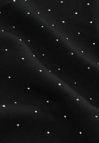 Schwarzer Stoff mit einer gerippten Textur, verziert mit verstreuten, kleinen, glänzenden Strasssteinen für zusätzlichen Detail- und Kontrast. 