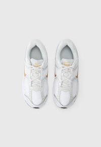 Białe sportowe sneakersy z siateczkową cholewką, z teksturowanym wzorem, złotymi akcentami i wyściełanym kołnierzem. Lekkie, z gumową podeszwą.