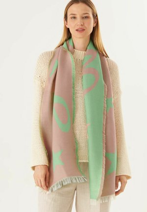 Lightweight scarf featuring abstract patterns in mint green and light pink, with fringed edges, worn over a knitted cream sweater.