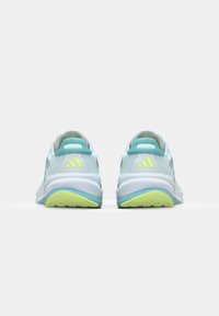 Scarpe sportive azzurre con accenti bianchi, dotate di una tomaia texturizzata, colletto imbottito e una suola di colore giallo-verde brillante. Branding a tre strisce.