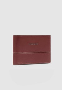 Bordeauxrood leren portemonnee met een gladde textuur, voorzien van witte stiksels en een verdiept logo gecentreerd aan de voorkant. Compact rechthoekig ontwerp.