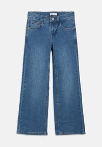 Τζιν με φαρδιά μπατζάκια σε μέτριο μπλε χρώμα. Διαθέτει κλείσιμο με κουμπί, πέντε τσέπες και εμφανή ραφές στις ένώσεις. Πλατιές, ίσιες μπατζάκια.