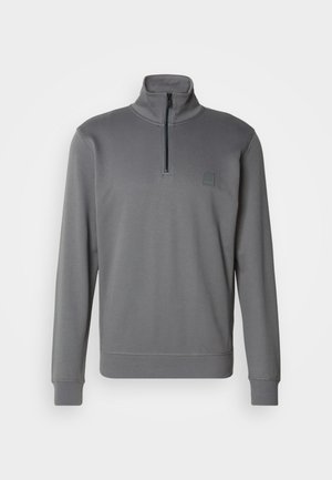 Pullover grigio con collo alto e zip a metà davanti. Presenta un tessuto testurizzato e un piccolo logo ricamato sul petto.