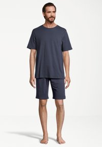 Marinblå bomulls T-shirt och shorts-set. T-shirten har rund halsringning och korta ärmar; shortsen är knälånga med ett elastiskt midjeband.