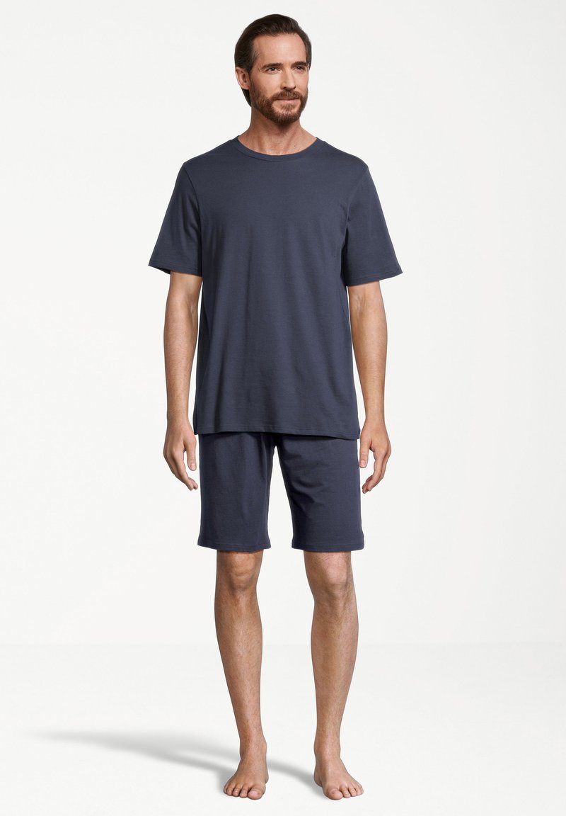 Marinblå bomulls T-shirt och shorts-set. T-shirten har rund halsringning och korta ärmar; shortsen är knälånga med ett elastiskt midjeband.