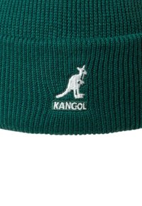 Gorro de punto verde con textura acanalada, que presenta un logo de canguro blanco y el texto "KANGOL" en un dobladillo.