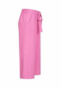 Rosa weit geschnittene Hose mit elastischem Bund, seitlichen Taschen und einer Bindeschleife in der Taille. Glattes Material, knöchellang.