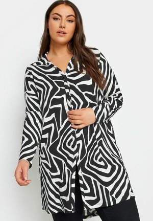 Schwarz-weiße Button-up-Bluse mit Zickzackmuster, langen Ärmeln und lockerer Passform, aus strukturiertem Stoff gefertigt.