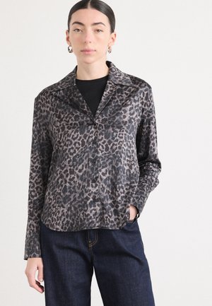 Leopardmønster knappet skjorte i nyanser av grått og svart, med krage og lange ermer, kombinert med blå denimbukser.